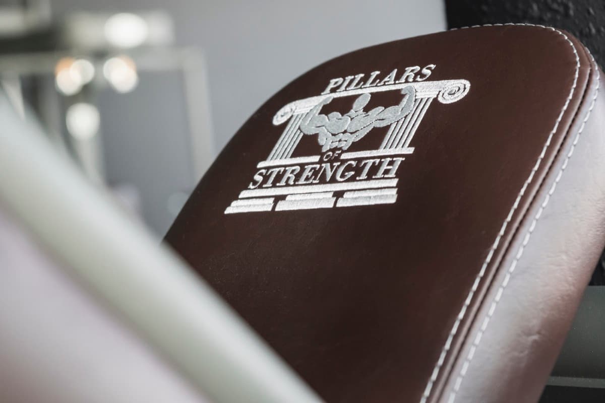 Pillars of Strength — Logo-Stickerei auf Telju Kraftgerät-Polster